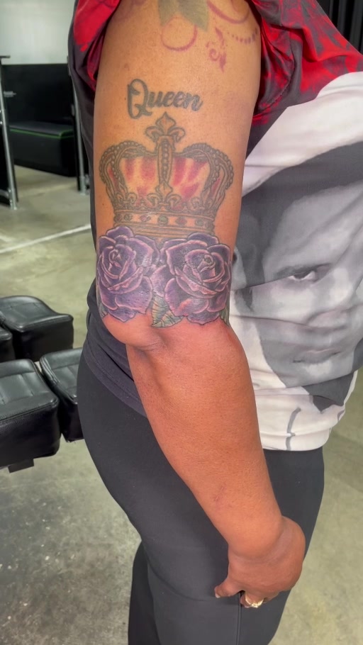 Crown and purple roses upper-arm tattoo
