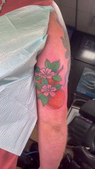Bright red floral forearm tattoo