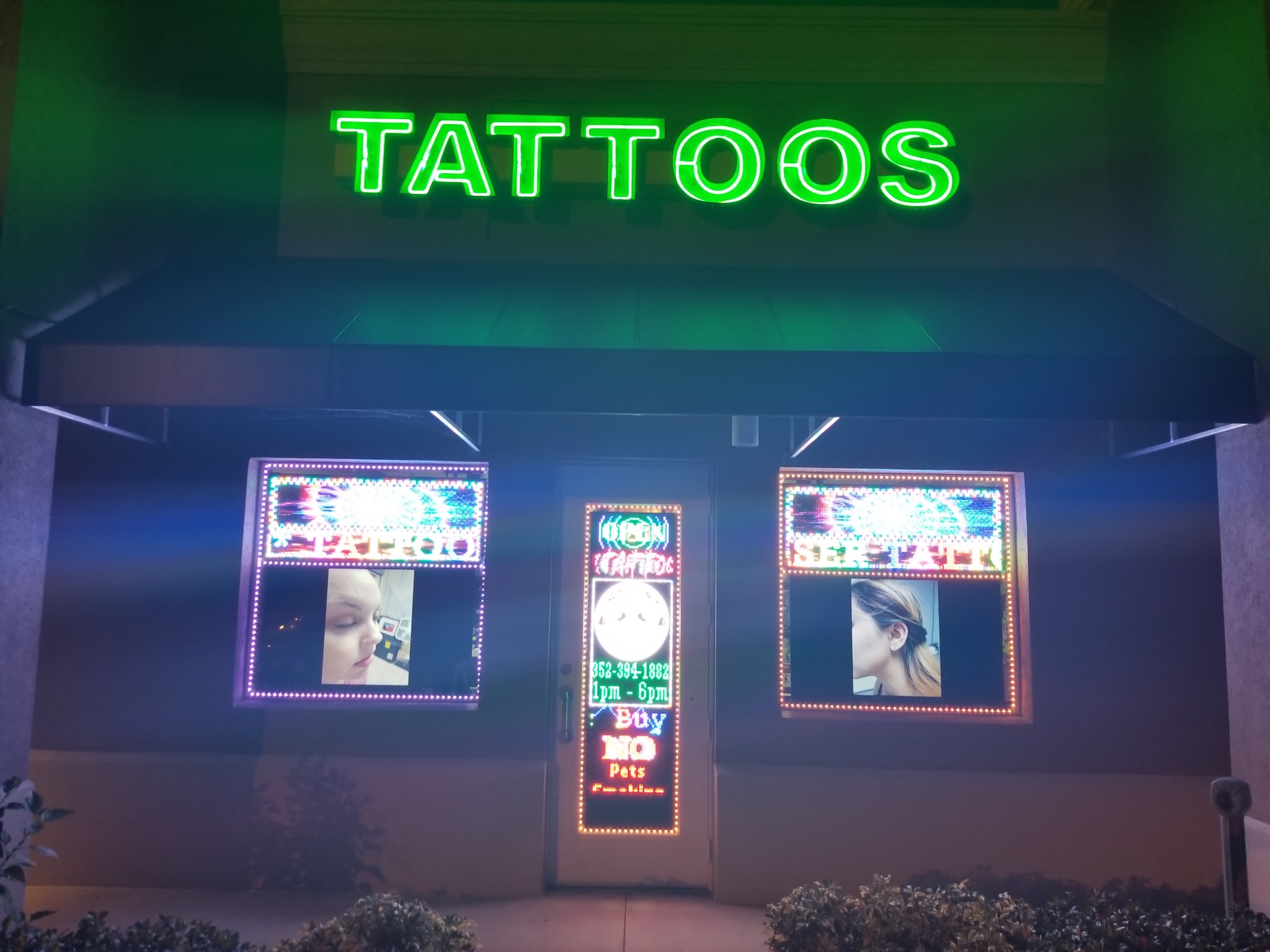 Ink Ink Tattoos storefront at night with illuminated green signs